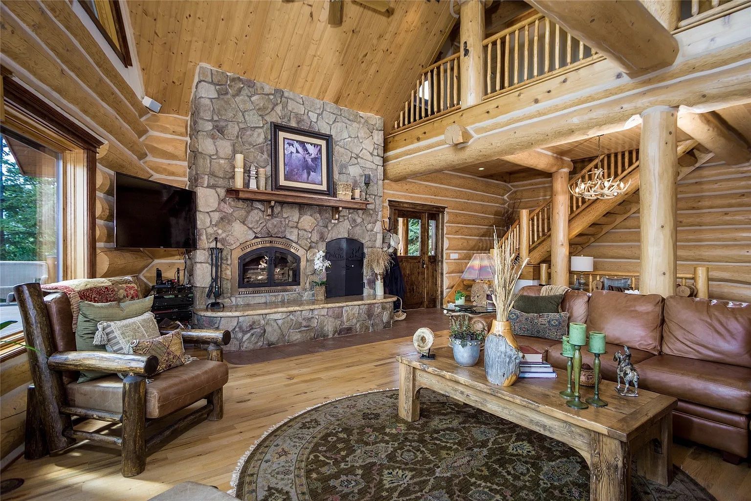 Rustic living room with stone fireplace, perfect for cozy evenings at The Ridge lodge vacation rental.