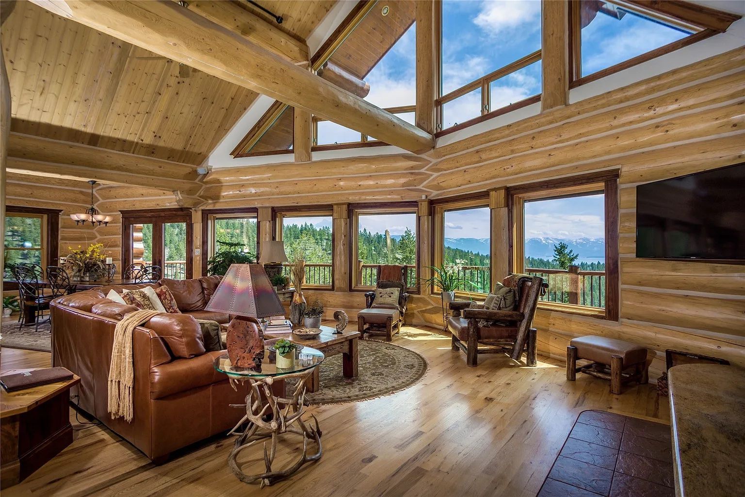 Upstairs living room with panoramic windows and mountain views, cozy relaxation space in The Ridge lodge.