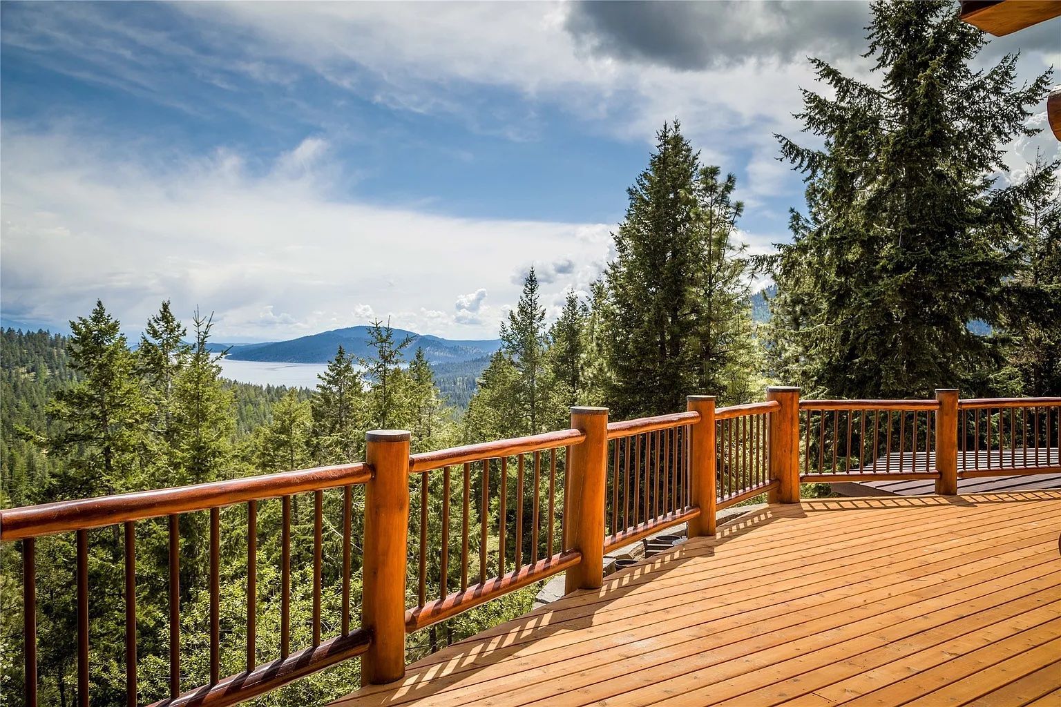 Balcony view overlooking forest and Flathead Lake at The Ridge, perfect for scenic Montana weddings and events.