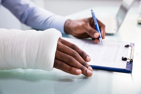 Injured Woman Filling Work Injury Claim Form — Pitman, NJ — Affordable Insurance Agency