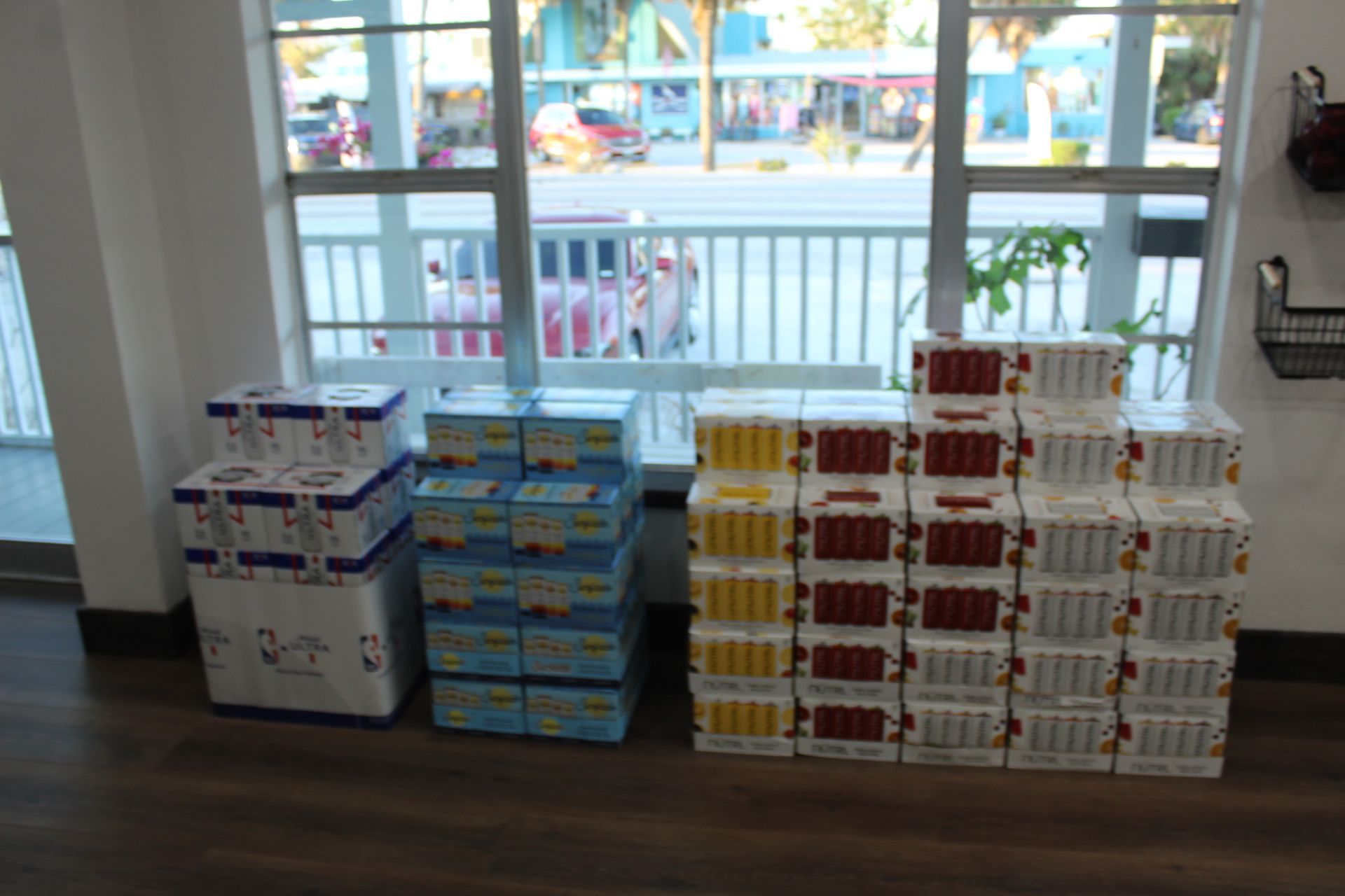 A bunch of boxes are stacked on top of each other in front of a window.