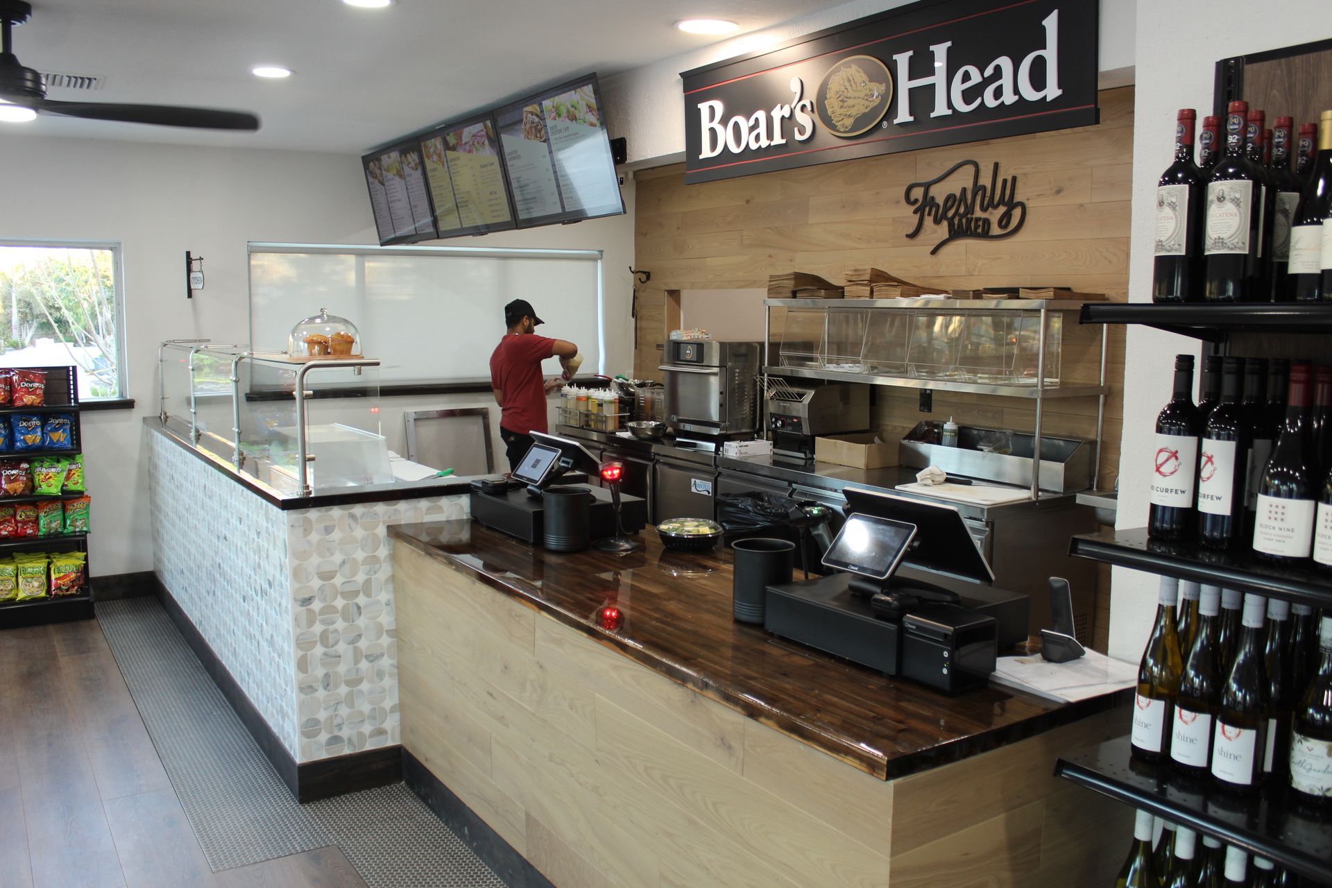 A man is standing behind a counter in a restaurant.