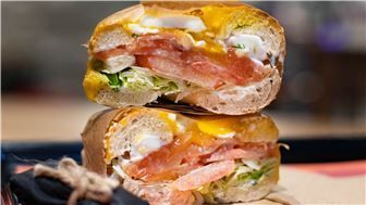 A close up of a sandwich stacked on top of each other on a table.