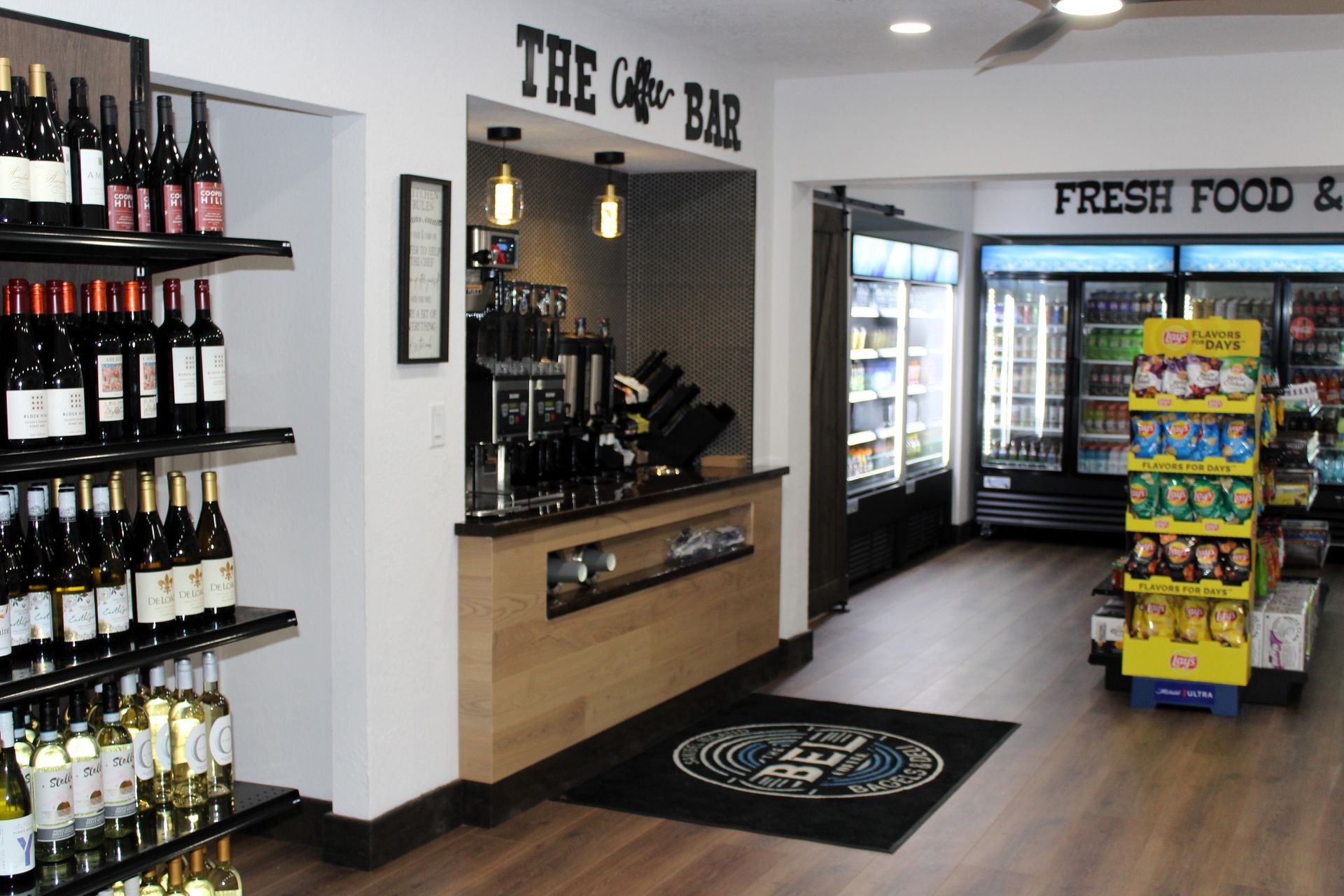 A store with bottles of wine on shelves and a sign that says the cafe bar