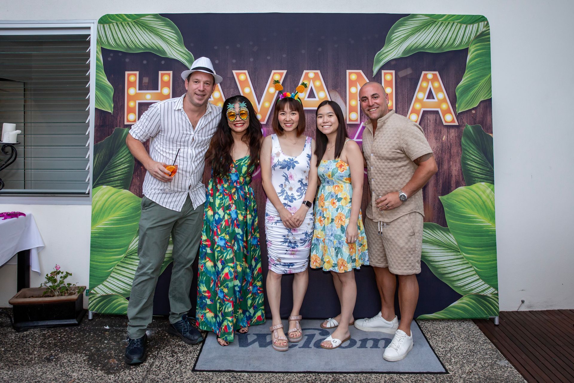 Five people smiling in front of a 