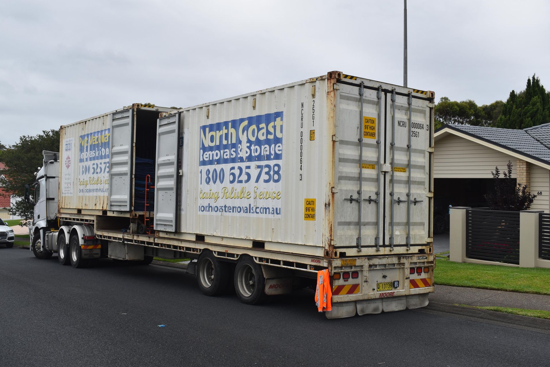 A Semi-Trailer Truck With Two Shipping Containers, Parked on a Residential Street, One Container Door Open — Frontline Removals And Storage in Port Macquarie, NSW