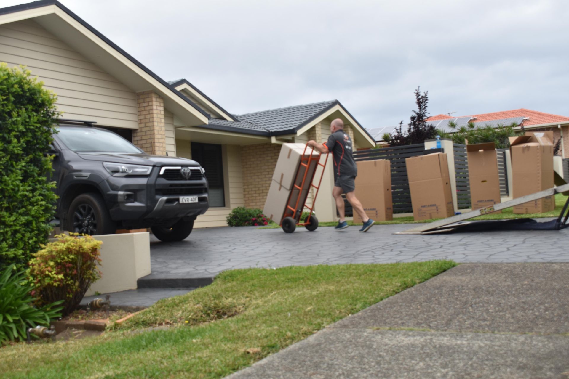 Man Moving Boxes With a Dolly Into a Truck  — Frontline Removals And Storage in Port Macquarie, NSW