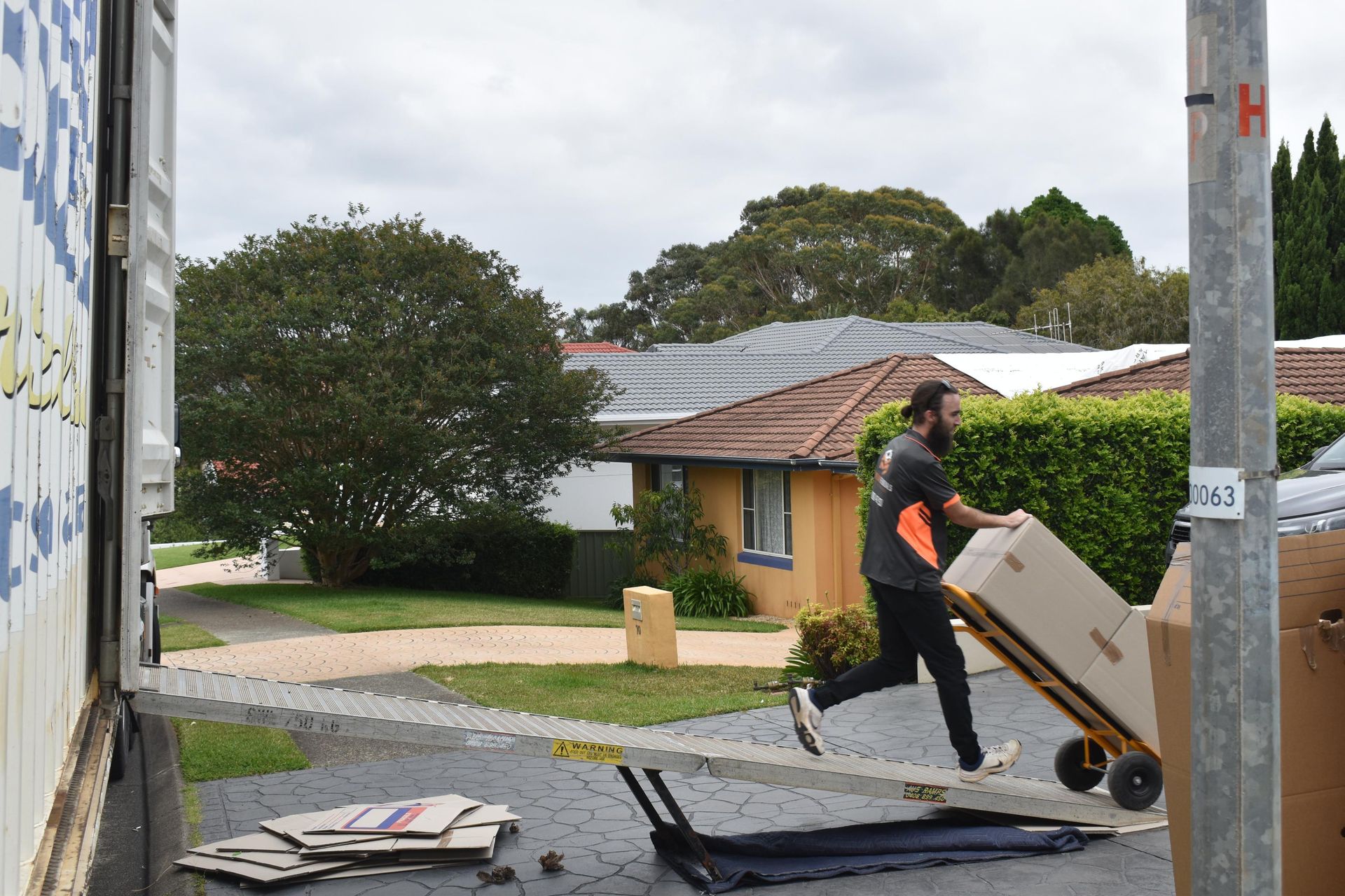 Man Running, Pushing Box on a Hand Truck — Frontline Removals And Storage in Port Macquarie, NSW