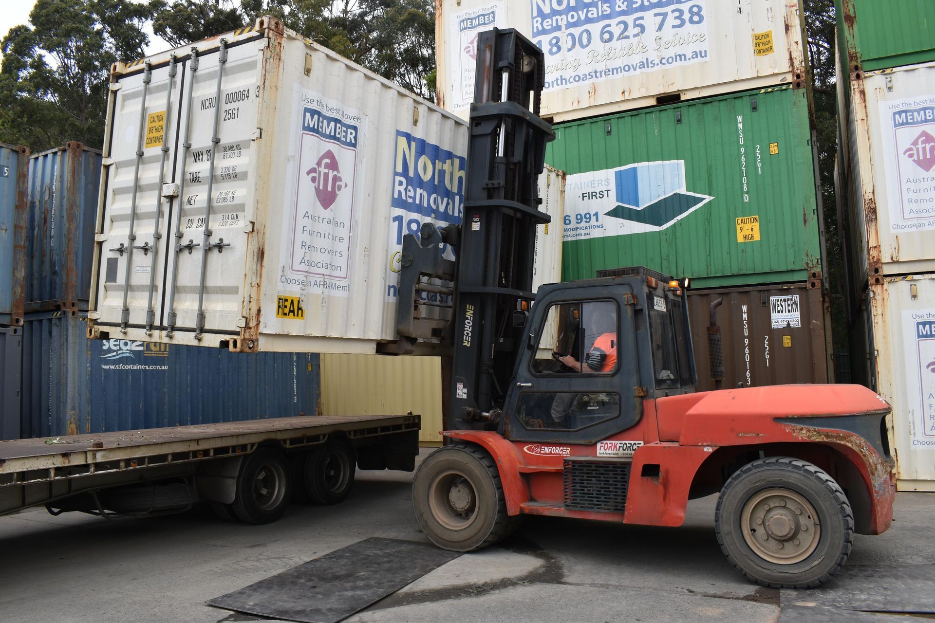 Forklift Lifts a Shipping Container — Frontline Removals And Storage in Port Macquarie, NSW