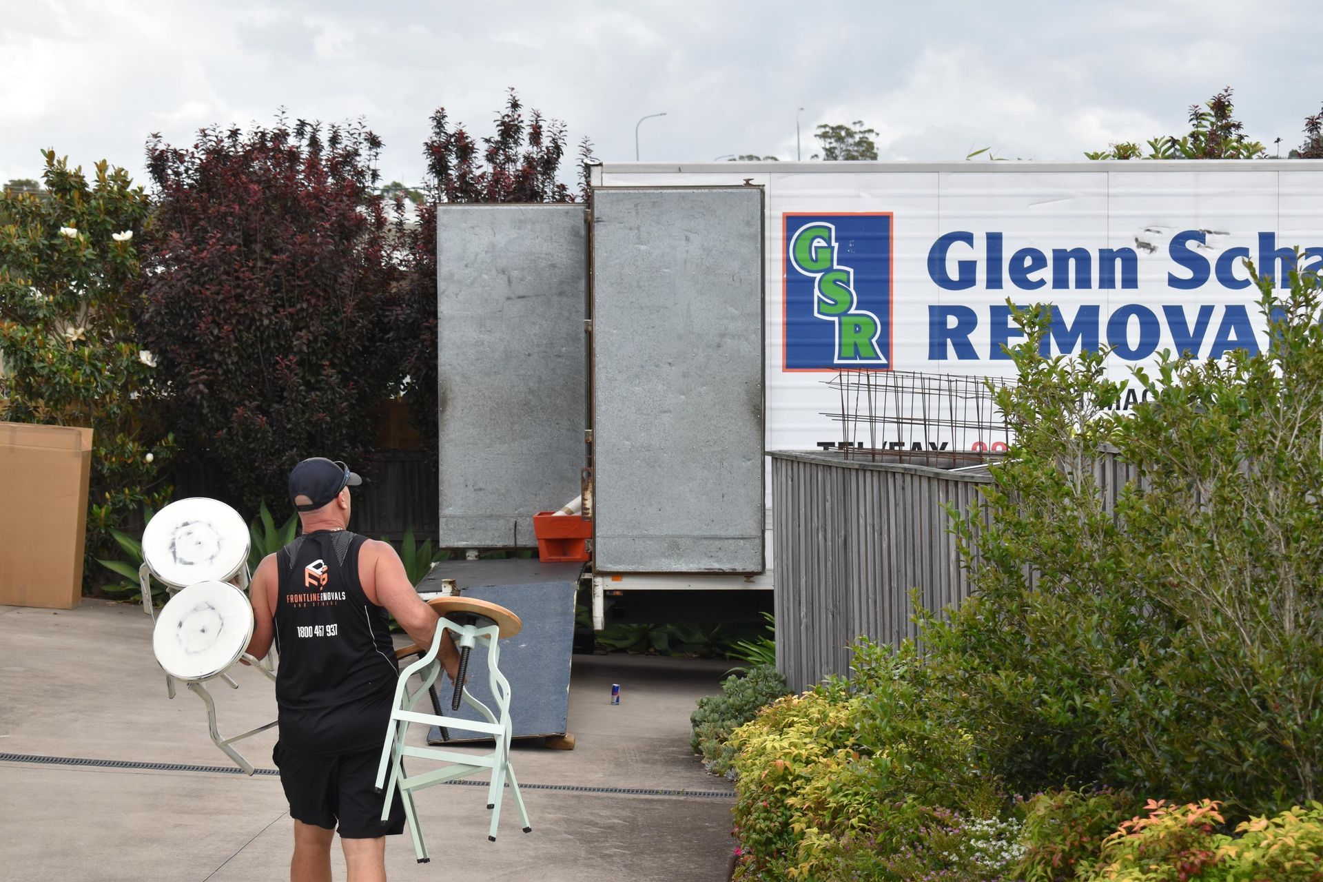 Man Carrying Objects Towards a Removal Truck — Frontline Removals And Storage in Port Macquarie, NSW