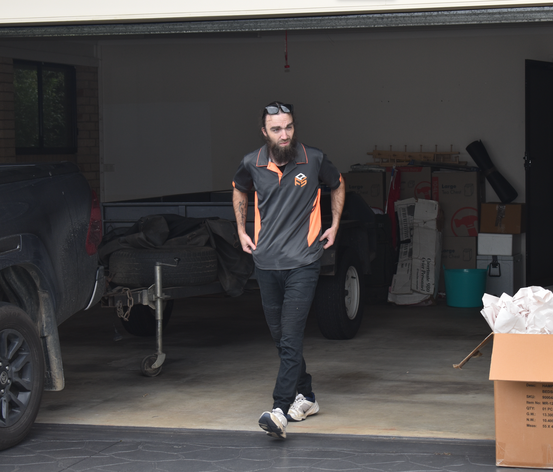 Man And Woman Sit On Moving Boxes With A Drawing Of A House — Frontline Removals And Storage in Sunshine Coast, QLD