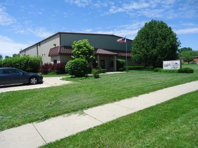 Blue convertible Corvette parked on pavement. Chrome details, black convertible top.