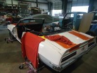 White and orange convertible car in a garage, under construction with red cover over the side.
