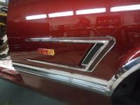 Red classic car side with chrome trim and 