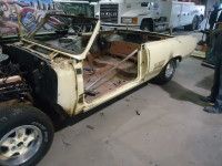 Yellow convertible car undergoing restoration in a garage.