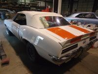 White convertible car with orange stripes parked inside a garage.