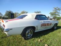 White convertible car with red and orange stripes on a grassy lawn.