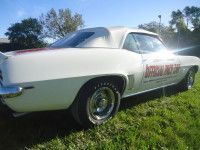 White convertible car parked on grass, with 