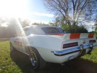 White and orange 1969 Chevrolet Camaro, a race car, outdoors on grass.