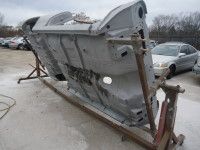 Car chassis, flipped upside down on a rotisserie, outdoors.