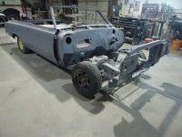 Partially disassembled gray convertible car in a workshop.