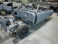 Gray classic car convertible frame in a workshop, partially assembled.