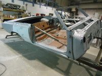 Partially assembled classic convertible car in a workshop.