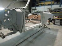Partially assembled classic car body in a workshop.