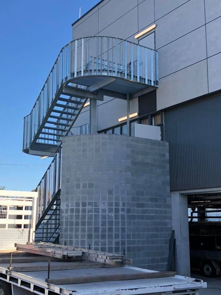A Man is Grinding a Piece of Metal in a Factory — Burke Metal Fabrication In Taree, NSW