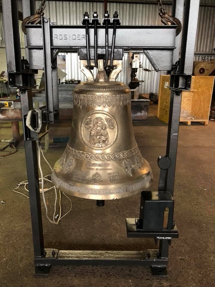 A large church bell hanging from a black steel frame — Burke Metal Fabrication In Taree, NSW