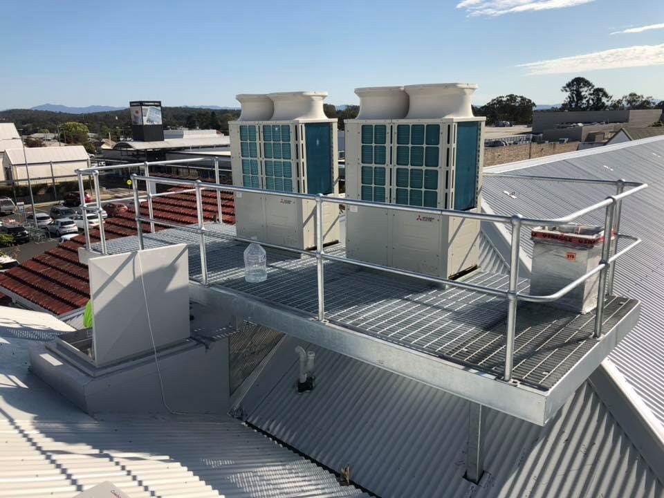 A couple of air conditioner units with a steel rail around it for safety on a roof — Burke Metal Fabrication In Taree, NSW