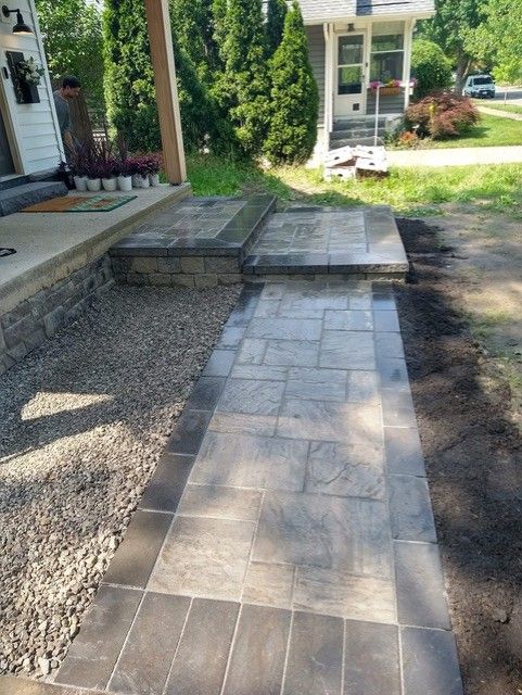 A stone wall with steps leading up to it in a garden.