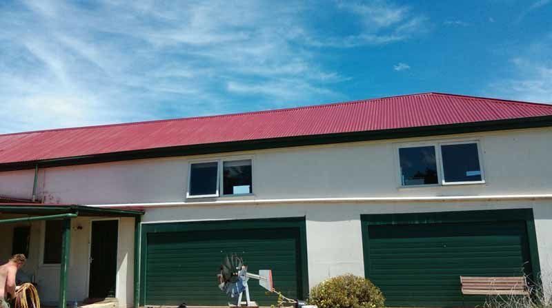 restored red roof on white house