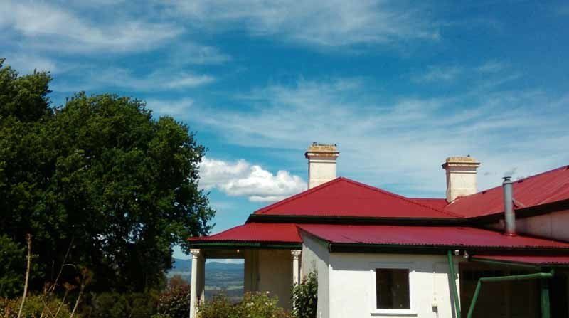 restored red roof on white house