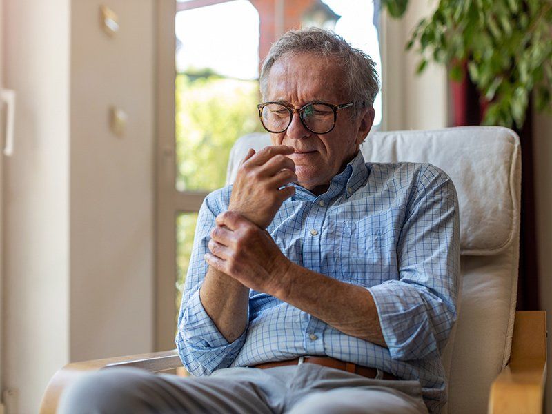 Senior Man with Arthritis Rubbing Hand — Broadview Heights, OH — Broadview Chiropractic