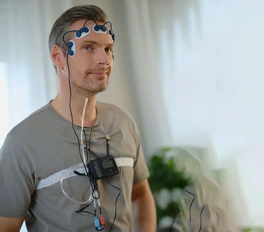 A Man is Wearing a Device on His Head — Mid North Coast Sleep Clinic in Taree, NSW