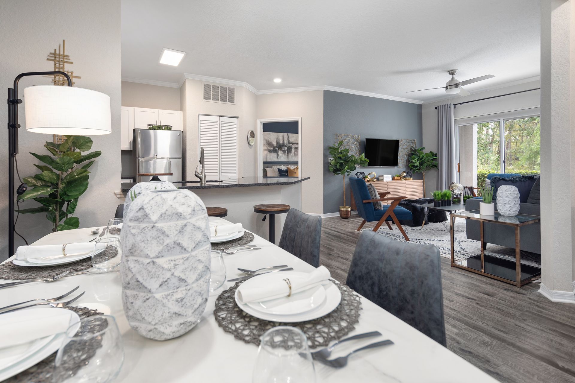 A dining room table with plates and silverware on it in a living room.