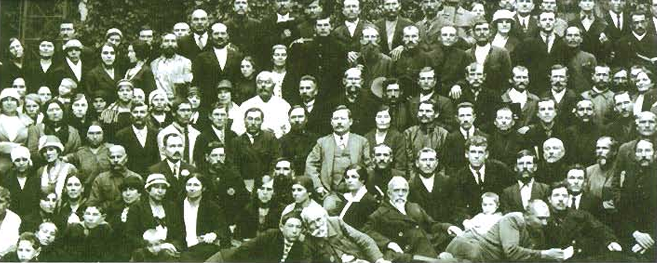 Group of people posing for a photo, primarily in dark clothing.