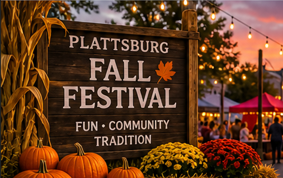Plattsburg Fall Festival sign with pumpkins, flowers, and warm string lights at dusk