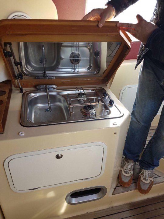 Una persona in piedi accanto a una stufa con il coperchio aperto