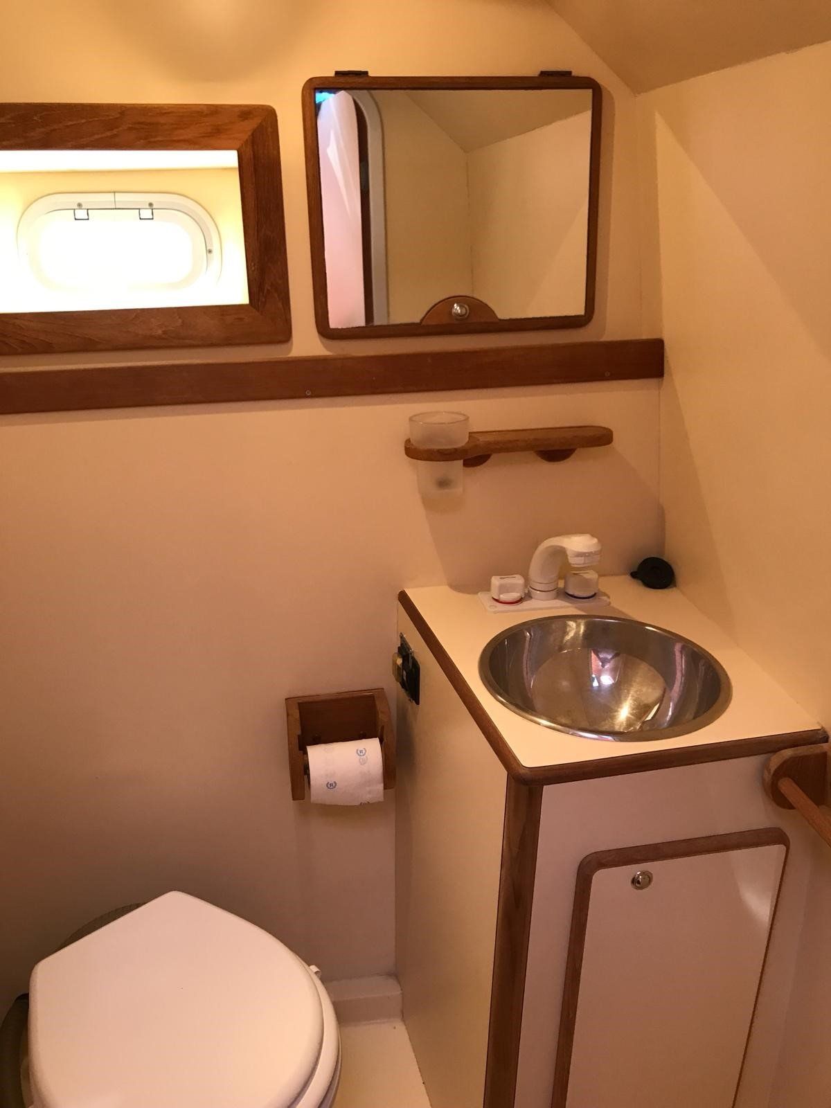 Un bagno con un water un lavandino e uno specchio