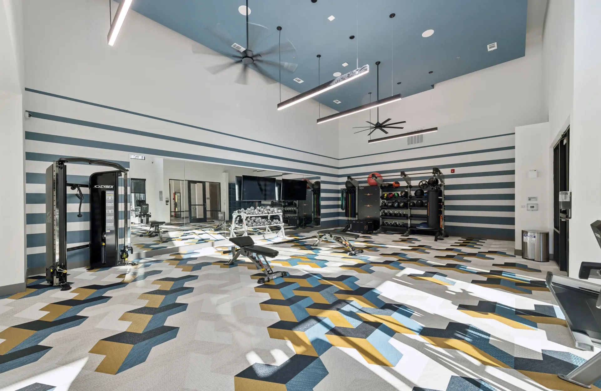 Modern fitness center with weight machines, free weights, and cardio equipment.