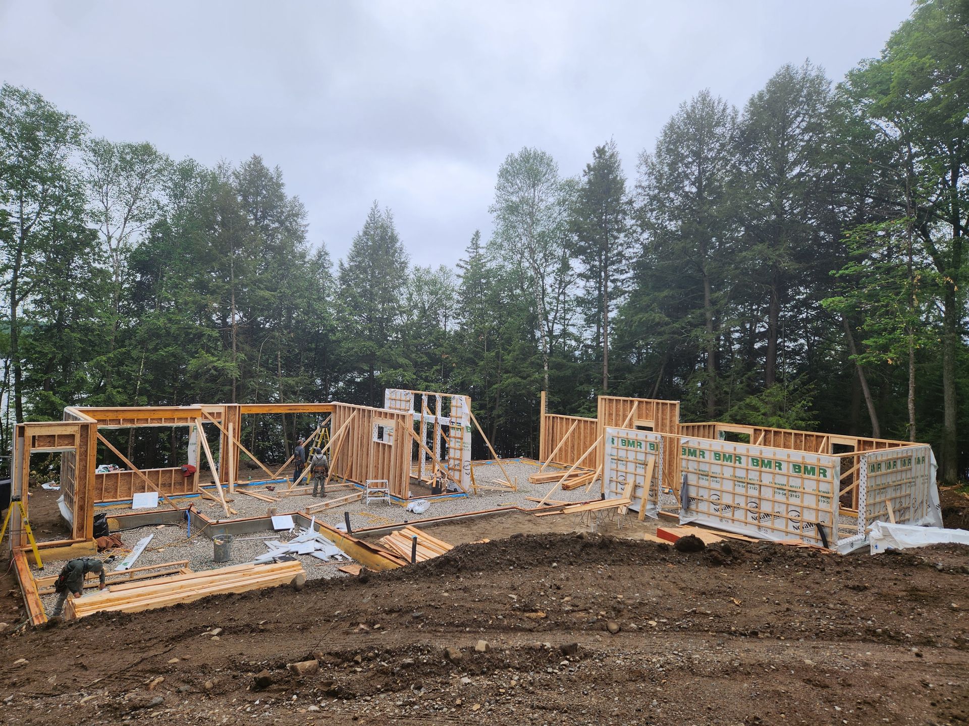 Une maison est en construction dans un champ avec des arbres en arrière-plan.