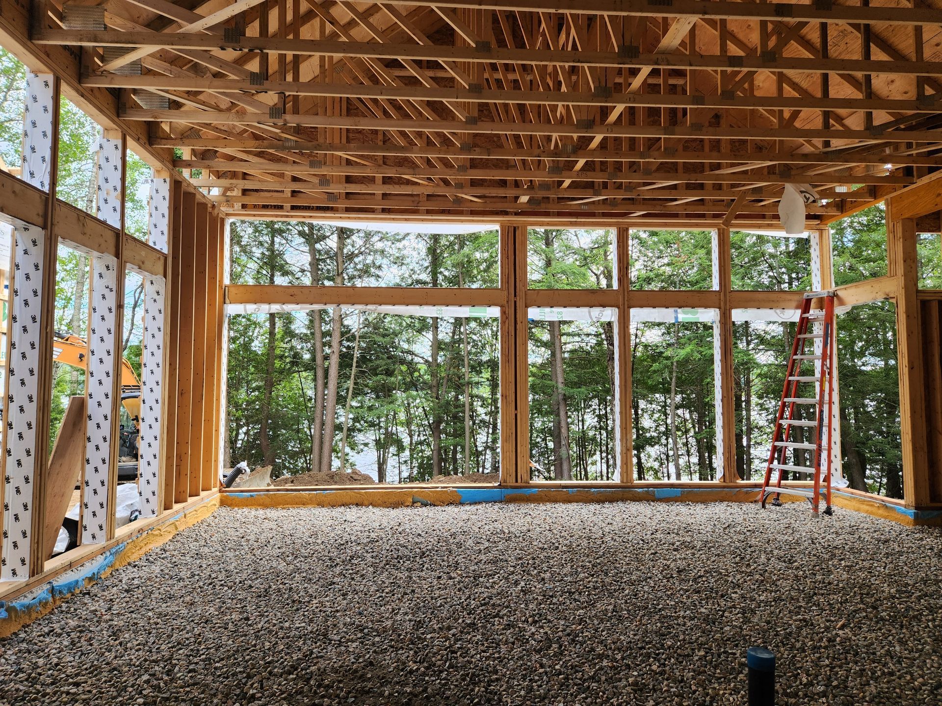 Une grande pièce en construction avec beaucoup de fenêtres et une échelle.