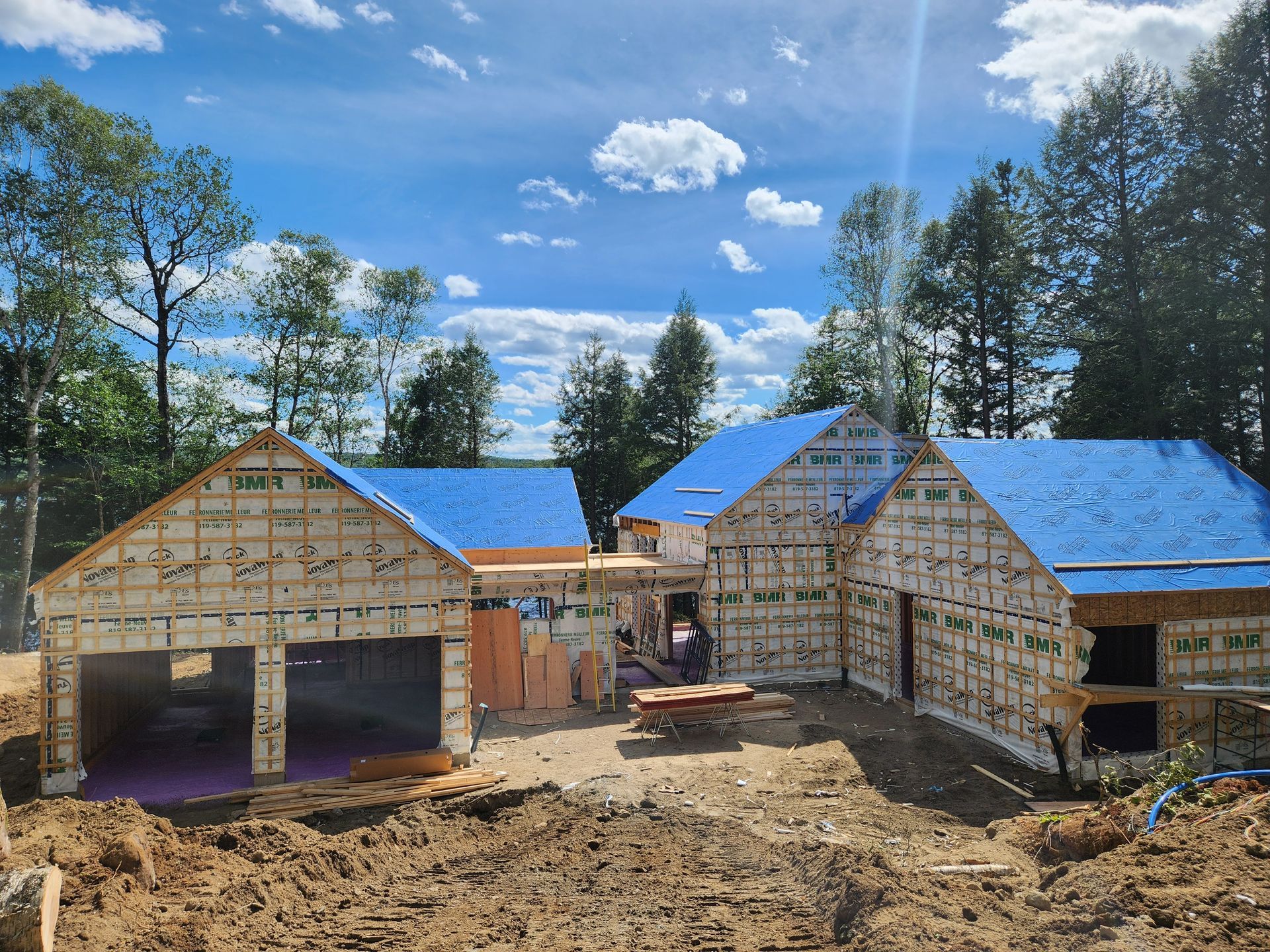 Une maison est en construction avec un toit bleu.