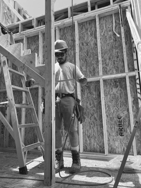 Une photo en noir et blanc d'un ouvrier du bâtiment dans un bâtiment en construction.