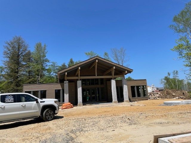 Un camion blanc est garé devant un bâtiment en construction.