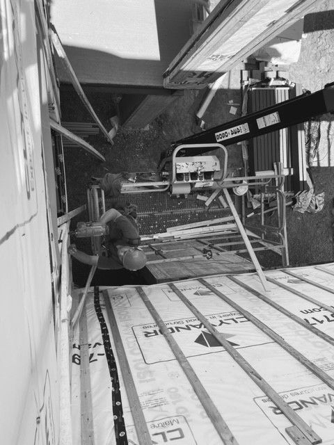 Une photo en noir et blanc d'un chantier de construction avec une grue.