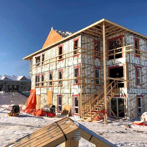 Un grand bâtiment est en construction sous la neige.