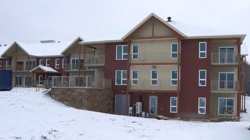 Un grand bâtiment avec beaucoup de fenêtres est recouvert de neige